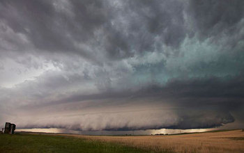 Photo of sky and a large wall cloud arcs around a rotating thunderstorm updraft in Nebraska.